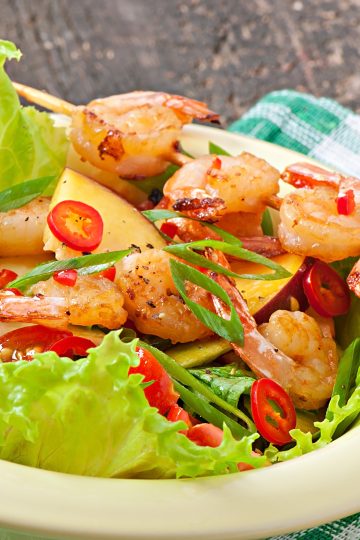 Shrimp salad with peaches, tomato, avocado and lettuce