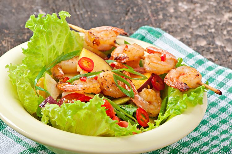 Shrimp salad with peaches, tomato, avocado and lettuce